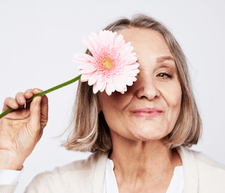 mujer con una flor tapándose un ojo